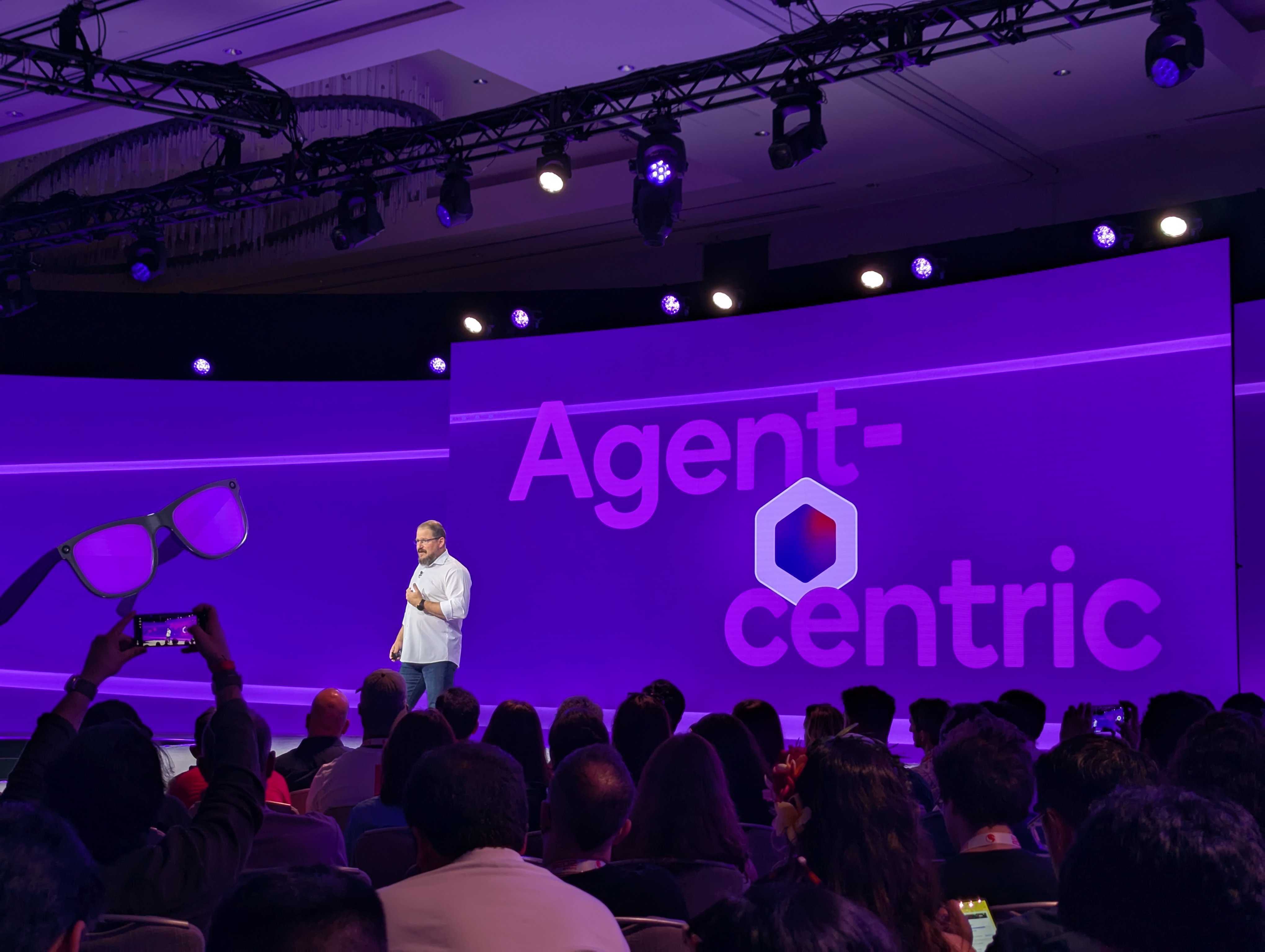 Cristiano Amon speaking at Snapdragon Summit on stage with 'Agent-centric' displayed behind him.