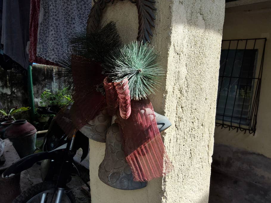 A decorative arrangement of pine branches and ribbons on a wall.