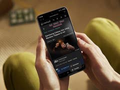 A person holding a Samsung Galaxy device with a web browser open on the screen.