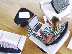 Woman sitting on a chair with a laptop and phone