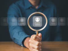 Person using a magnification glass to look at virtual jobs