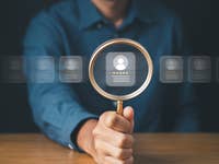 Person using a magnification glass to look at virtual jobs