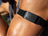 Close-up of an arm wearing a black Zepp fitness tracker on the bicep.