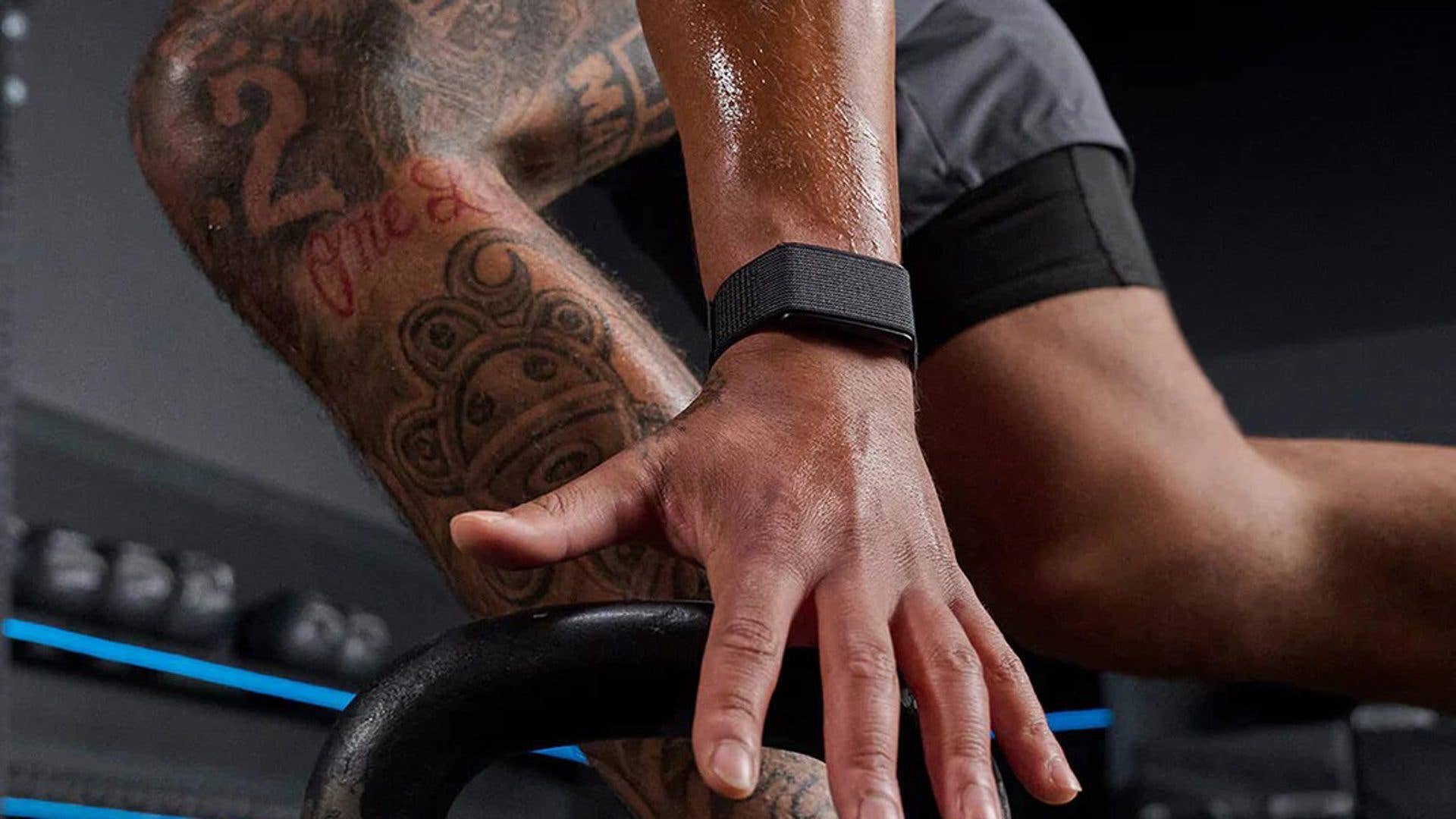 A close-up of a hand gripping a kettlebell, showcasing an Amazfit smartwatch on the wrist.
