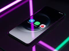 A smartphone displaying three messaging app icons: Telegram, WhatsApp, and Signal on a reflective surface with neon lights.