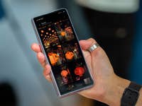 A person holding a Samsung Galaxy Z Fold 5 displaying a gallery of colorful lantern images.