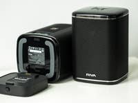 Two RIVA Arena speakers on a table, with one showing the battery compartment.