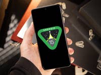 A person holding a phone with the Android 15 preview logo highlighted in the display