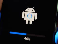 A hand holding a smartphone displaying an Android update progress screen at 46%.