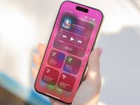 A hand holding an iPhone displaying ambient music controls and options.