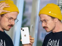 A person looking confusedly at the iPhone 14.