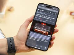 A person holding an iPhone showing the device reading a text for aloud.