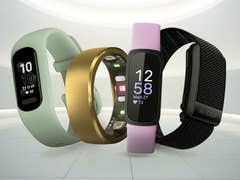 Three fitness trackers in various colors displaying heart rates and steps.
