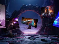 Futuristic monitors display vivid sci-fi scenes amid rocky alien landscape.