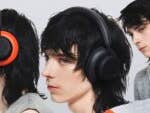 Three models wearing CMF headphones in various colors against a light background.