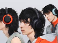 Three models wearing CMF headphones in various colors against a light background.