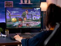 A person playing a fighting game on a computer with a keyboard, displaying action on the screen.