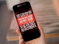 A smartphone displaying a warning QR code with text: 'POTENTIAL RISK! DO NOT SCAN!'