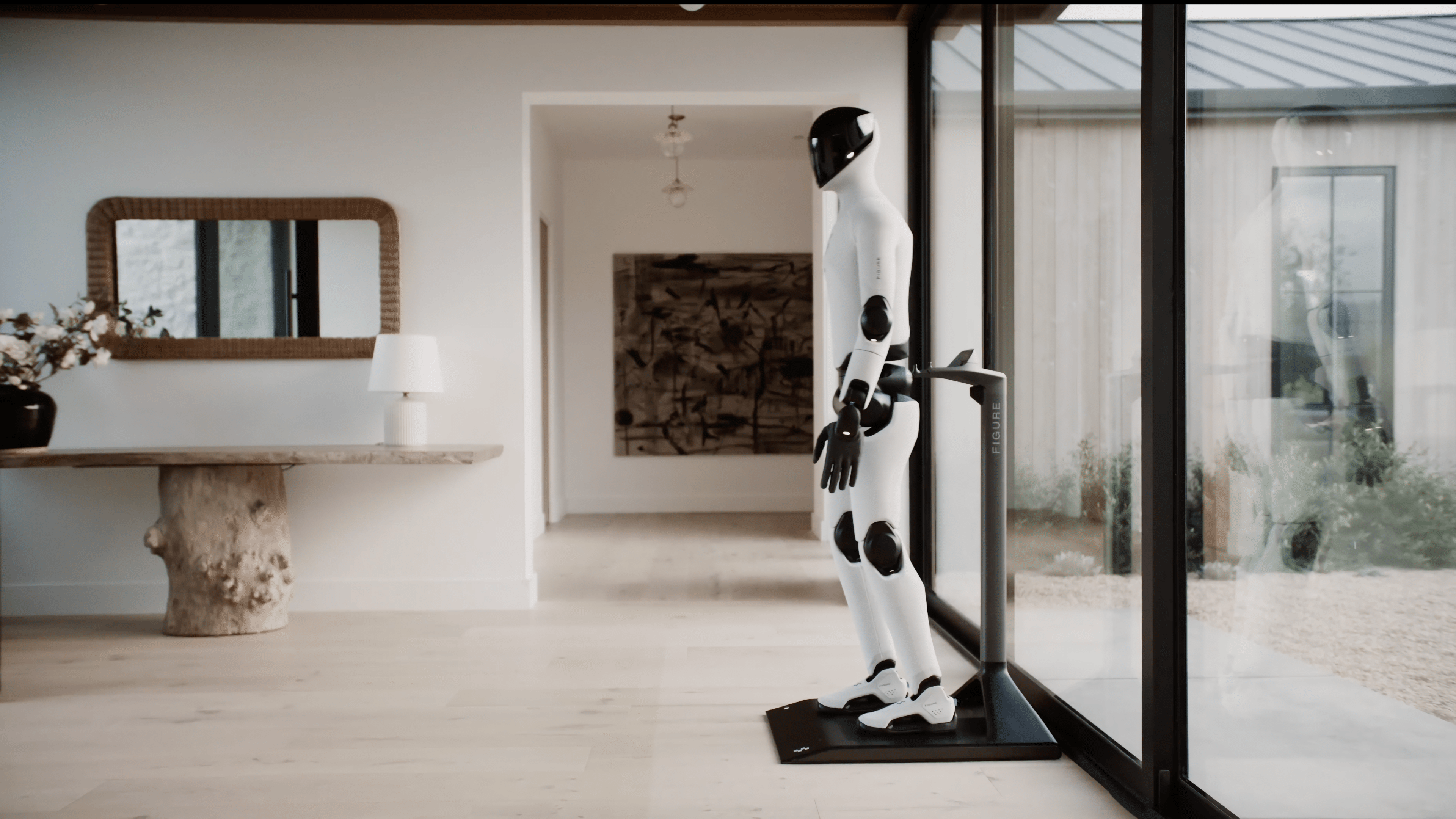 A humanoid robot stands in a modern interior next to a table and a large window.