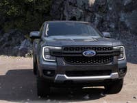 A gray Ford Ranger pickup truck parked on rocky terrain.