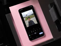 A Samsung Galaxy S24 FE displaying a selfie with a park background.