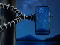 A phone mounted on a tripod, taking pictures of the stars.