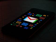A smartphone displaying the Gmail logo on a colorful background with various email icons.