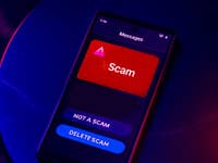 A smartphone screen displaying a message labeled 'Scam' with options 'Not a Scam' and 'Delete Scam'.