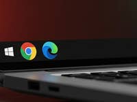 A close-up of a laptop screen showing the Windows logo and browser icons for Chrome and Edge.
