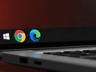 A close-up of a laptop screen showing the Windows logo and browser icons for Chrome and Edge.