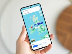 A person holding a Samsung Galaxy S24 FE displaying a map of the United Kingdom.