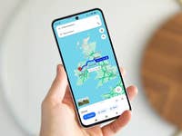 A person holding a Samsung Galaxy S24 FE displaying a map of the United Kingdom.