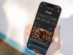 A hand holding a smartphone displaying Google News with a headline about the Philippines' Black Nazarene procession.