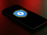 A smartphone displays the Google Password Manager logo on a dark background.