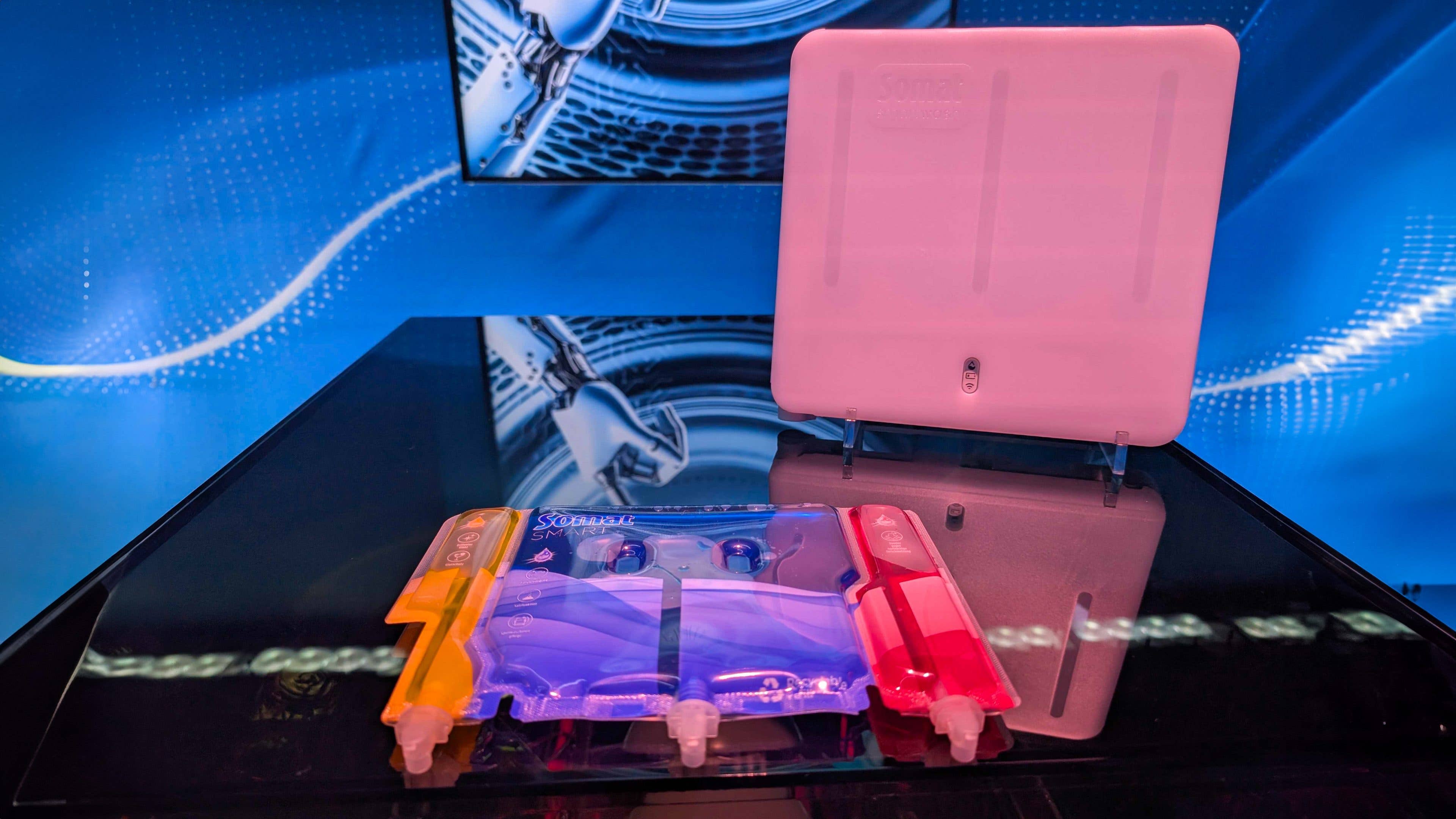A transparent device with colored sections displayed on a table at CES 2025, with a digital backdrop.