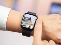 A person using the digital crown of the Apple Watch to zoom in the iPhone camera