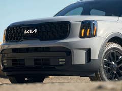 A close-up of a Kia Telluride SUV showcasing its front grille and headlights.