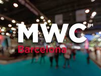 The MWC logo highlighted in an image with people walking in the halls of Fira Gran Via in Barcelona