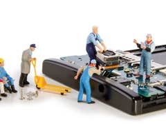 Miniature figures working on repairing a smartphone.