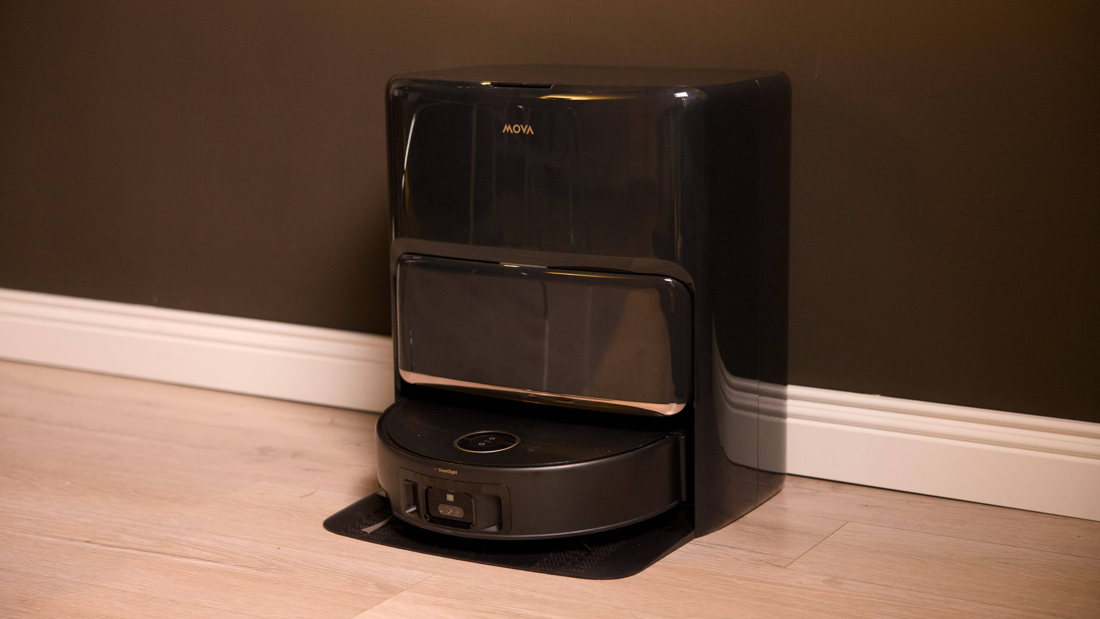 Mova Z60 Ultra Roller Complete, a black robotic cleaner against a dark wall.