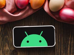 Android Robot on a phone with decorated Easter Eggs