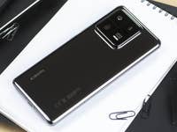 The Xiaomi 13 Pro laid diagonally flat on a white notebook with its black color on the back