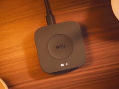 A Philips Hue smart lighting hub on a wooden surface.