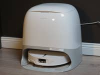 A Roborock Qrevo Curv 2 Pro robotic vacuum cleaner on a wooden floor.