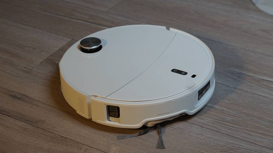 The Roborock Qrevo Curv 2 Pro robot vacuum cleaner on a wooden floor.
