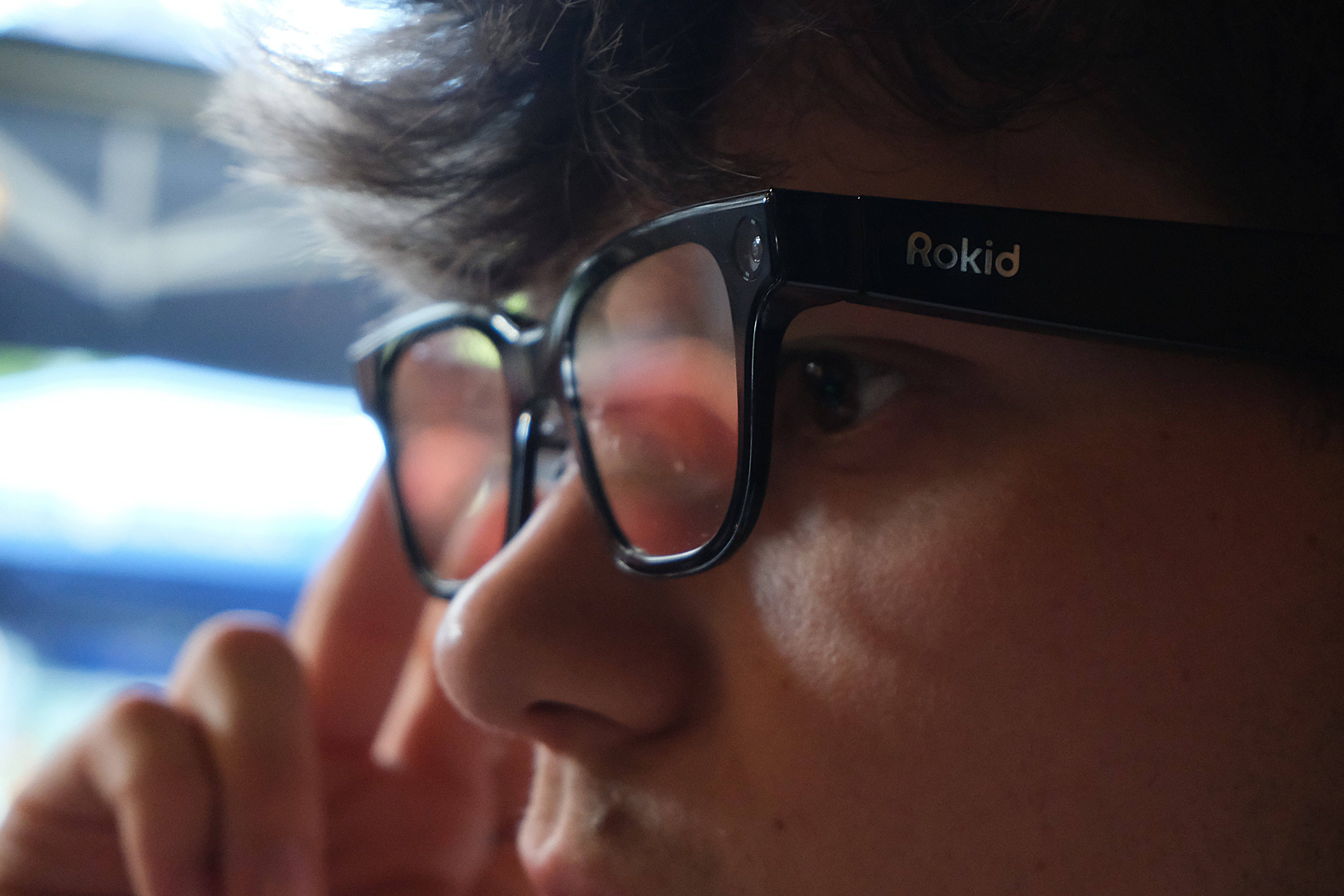 Close-up of Rokid glasses worn by a person, with a focus on the lenses and frame.