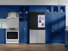 A modern kitchen featuring a Samsung refrigerator with a display, blue cabinetry, and a stainless steel oven.