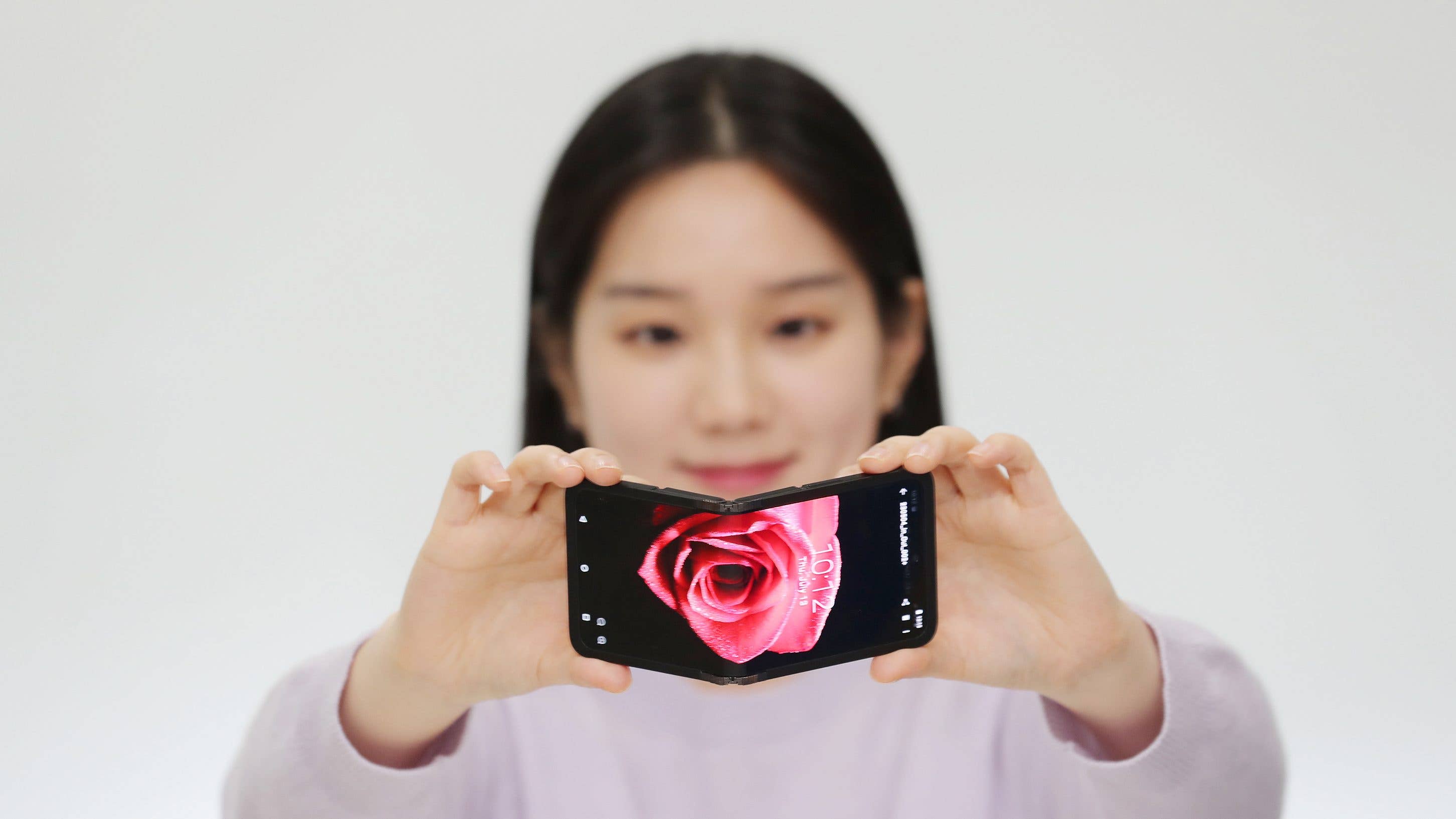 A person folding a flip phone