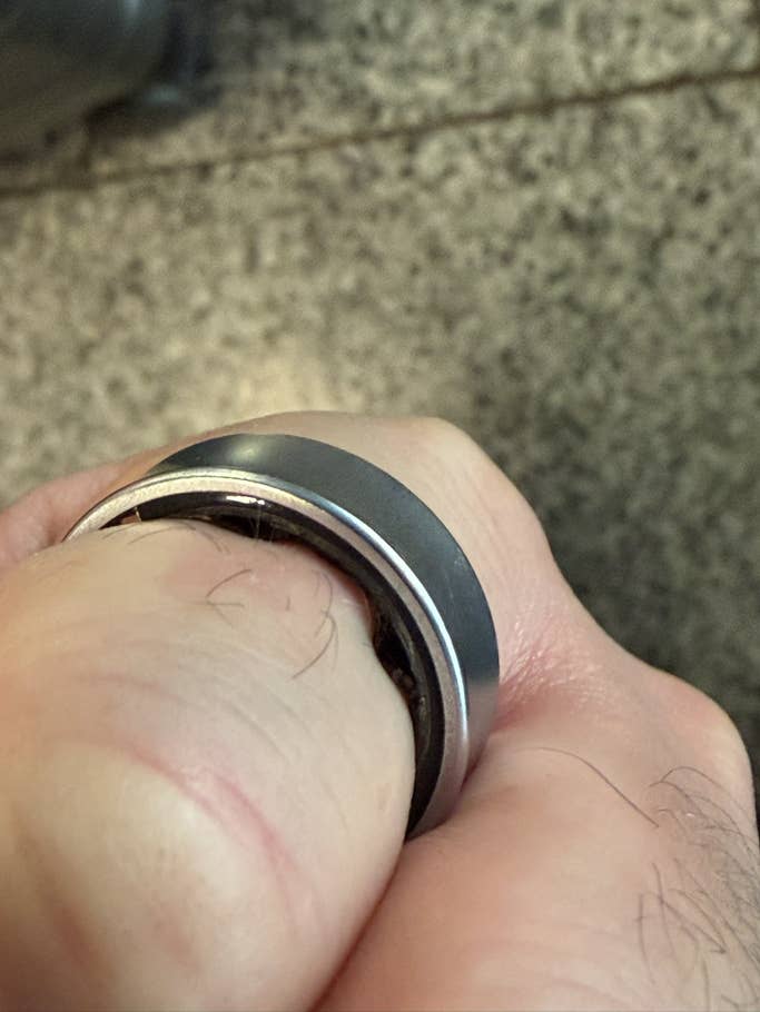 A close-up of a Samsung Galaxy Ring on a person's finger.