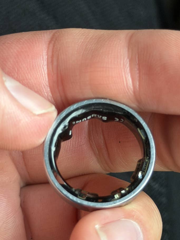 A person holds a Samsung Galaxy ring, showing the inner side with brand details visible.